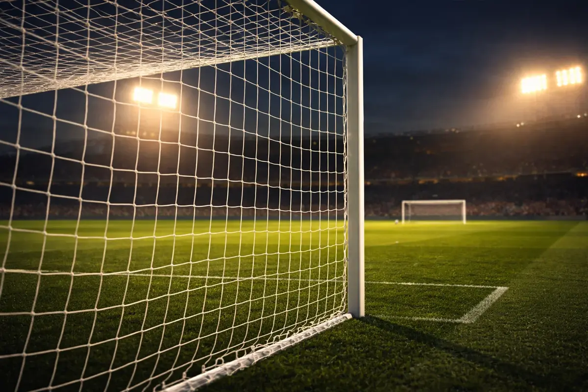 Fußballtor mit Netz und Rasen im Fokus bei Abendlicht